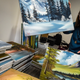 Sarah Stroll, executive assistant at Bob Ross, Inc., with a stack of Ross paintings on October, 15, 2018, in Herndon, Virginia.